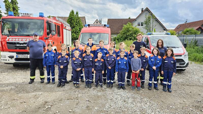 Gruppenfoto der Jugendfeuerwehr mit Ihren Betreuern vor Einsatzfahrzeugen