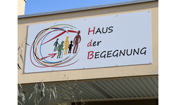 Schild mit Logo über Eingang Haus der Begegnung