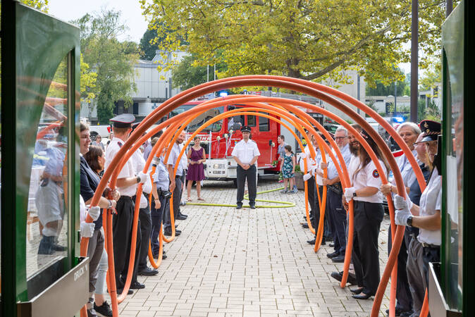 Die Feuerwehr steht mit Schlauchspirale spalier bei einer Hochzeit