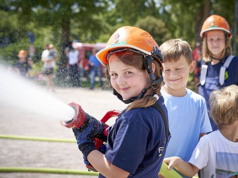 Jugendfeuerwehrmädchen mit Strahlrohr in der Hand